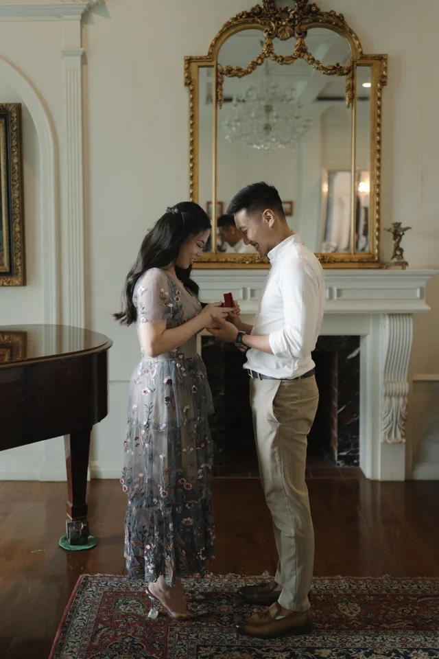 Mauric and Nadya holding hands before a gold-framed mirror