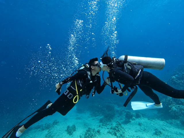 Mauric and Nadya sharing a kiss while scuba diving